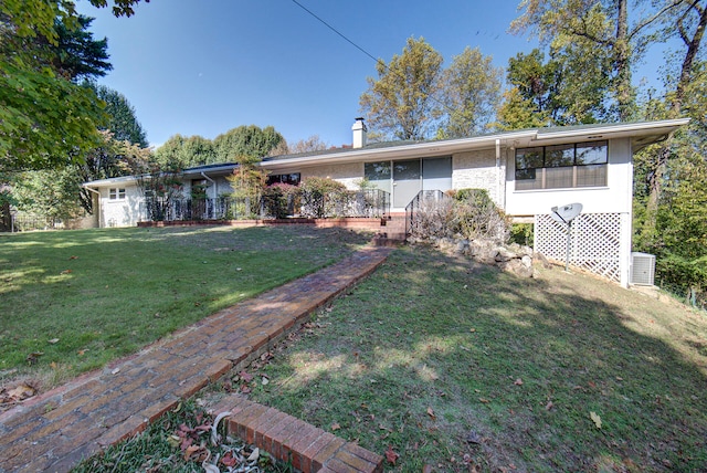 ranch-style home featuring central air condition unit and a front lawn