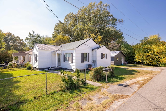 view of front of house featuring a front yard and central AC