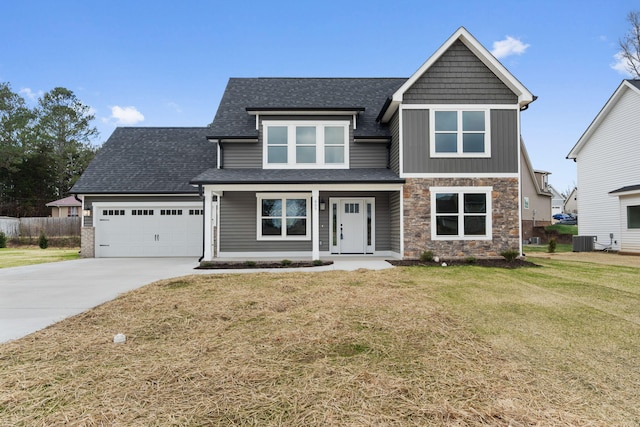 view of front of property featuring cooling unit, a garage, and a front lawn