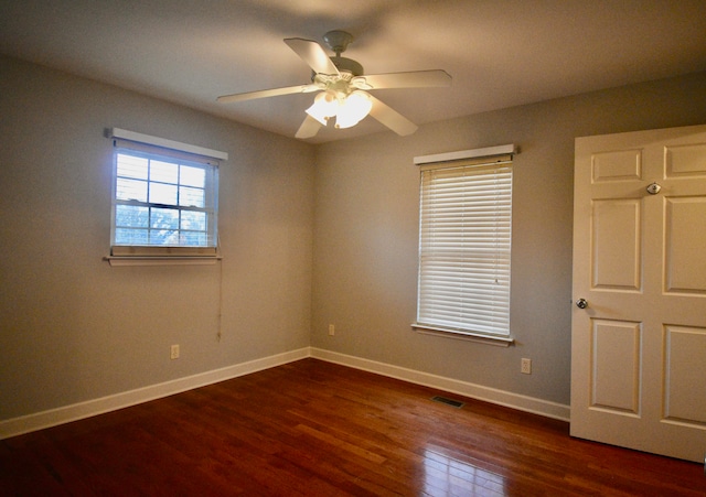 spare room featuring dark hardwood / wood-style flooring and ceiling fan