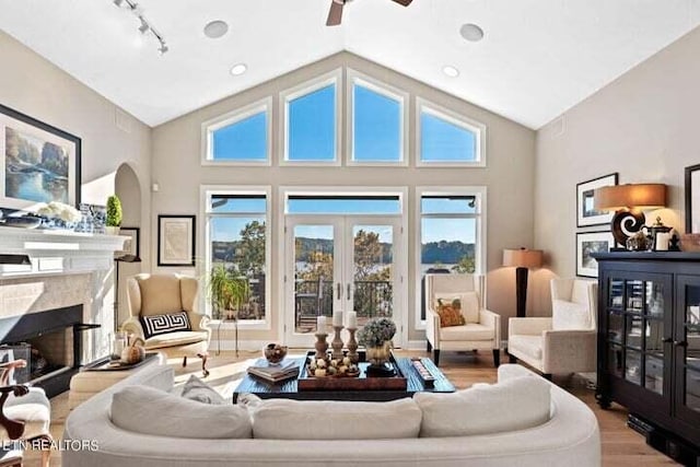 living room with french doors, wood-type flooring, high vaulted ceiling, and ceiling fan