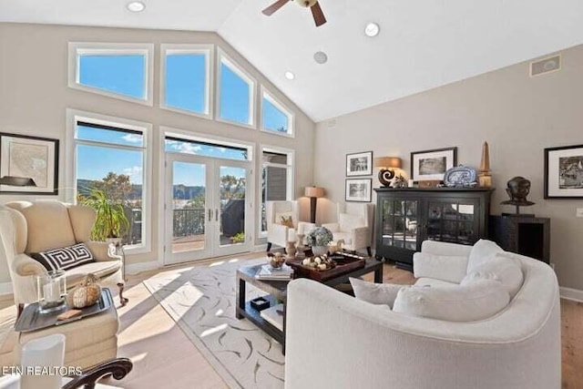 living room with french doors, ceiling fan, high vaulted ceiling, and light hardwood / wood-style flooring