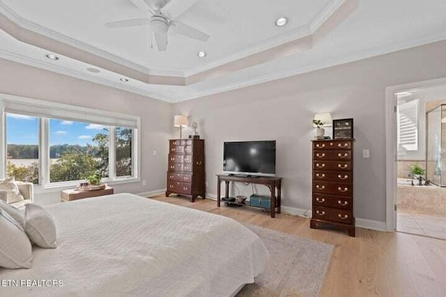 bedroom with light hardwood / wood-style flooring, ornamental molding, a tray ceiling, and ceiling fan