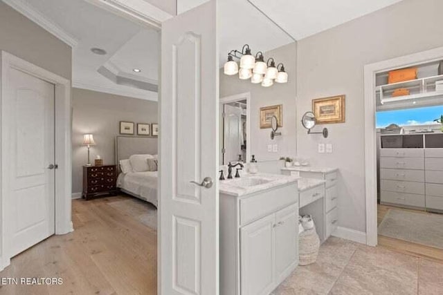 bathroom featuring vanity, hardwood / wood-style floors, and ornamental molding