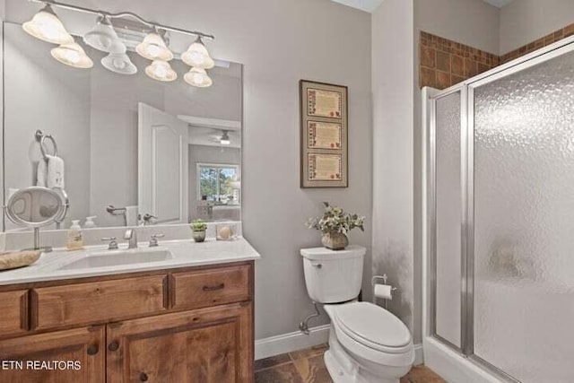 bathroom with vanity, toilet, and a shower with shower door