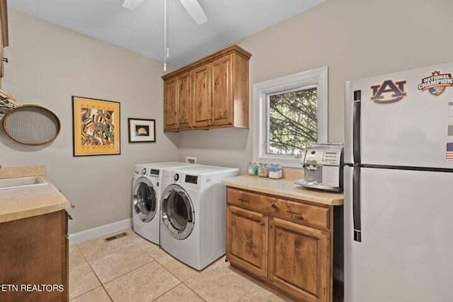 washroom featuring cabinets, ceiling fan, light tile patterned floors, sink, and washer and clothes dryer