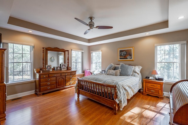 bedroom with multiple windows, ceiling fan, and light hardwood / wood-style flooring