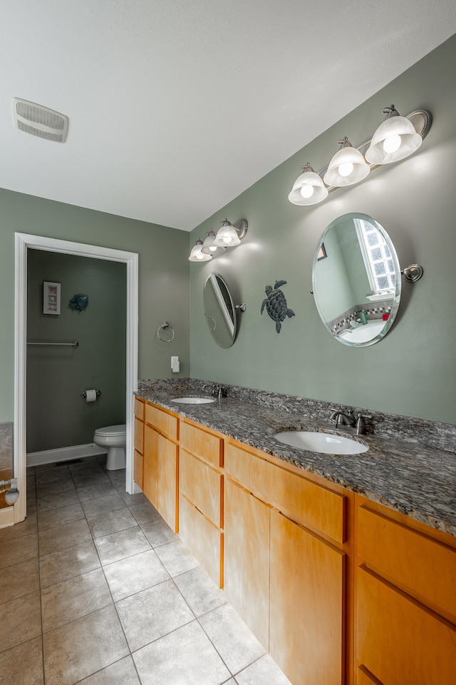 bathroom featuring vanity, toilet, and tile patterned floors