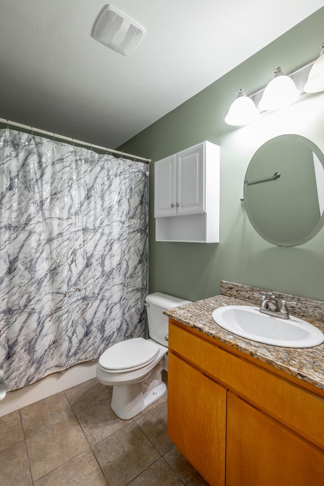 bathroom with tile patterned flooring, vanity, and toilet