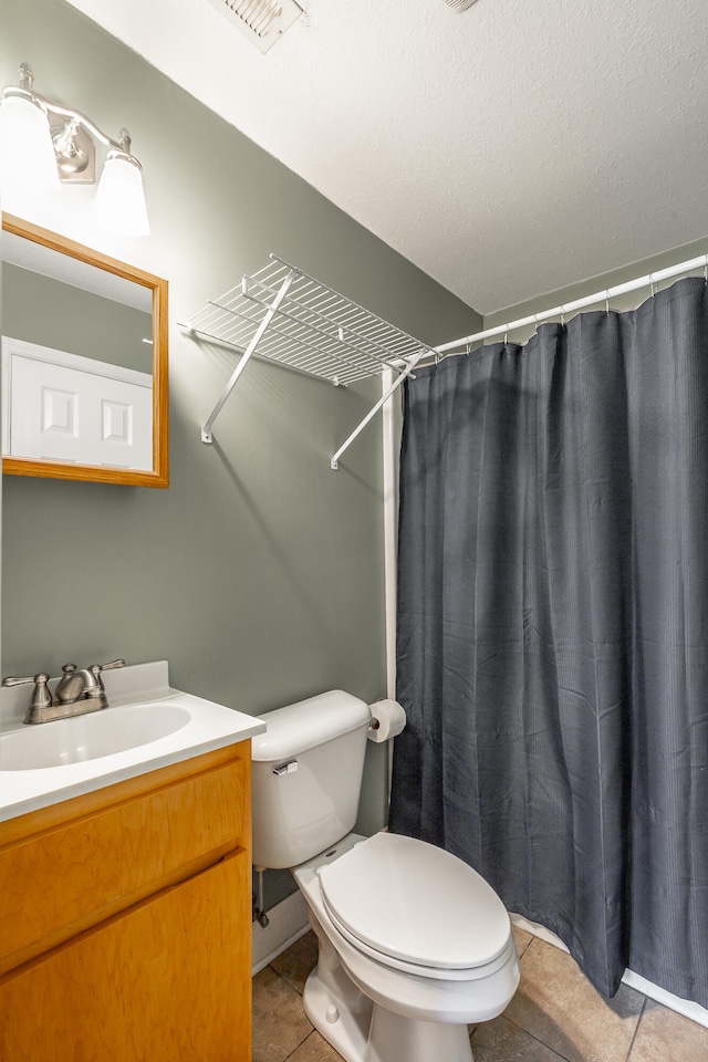 bathroom with tile patterned floors, curtained shower, vanity, toilet, and a textured ceiling