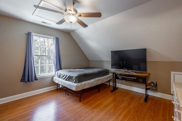 bedroom with ceiling fan, wood-type flooring, and vaulted ceiling