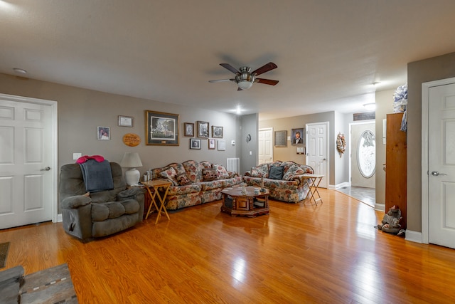 living room with wood-type flooring and ceiling fan