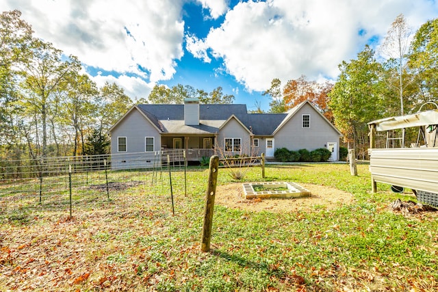 rear view of property featuring a yard