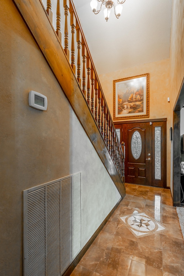 foyer entrance featuring a chandelier and a towering ceiling