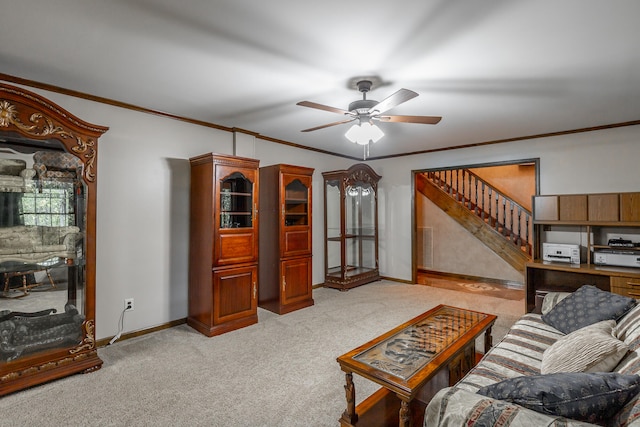 carpeted living room with ornamental molding and ceiling fan