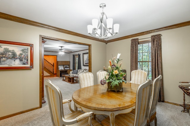 dining space with light carpet, crown molding, and ceiling fan with notable chandelier