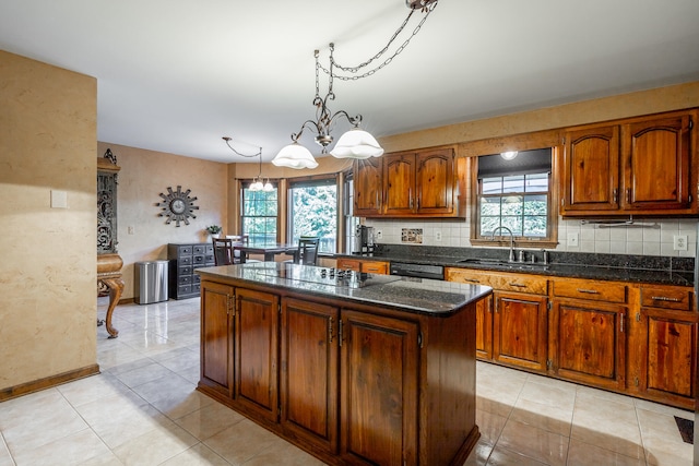 kitchen featuring an inviting chandelier, a healthy amount of sunlight, sink, and a kitchen island