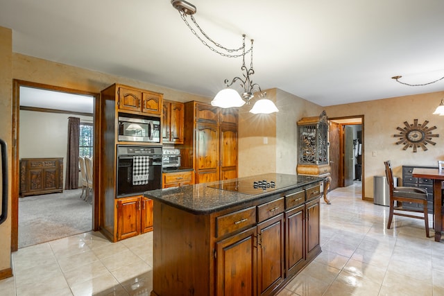 kitchen featuring black appliances, a center island, light carpet, decorative light fixtures, and a chandelier