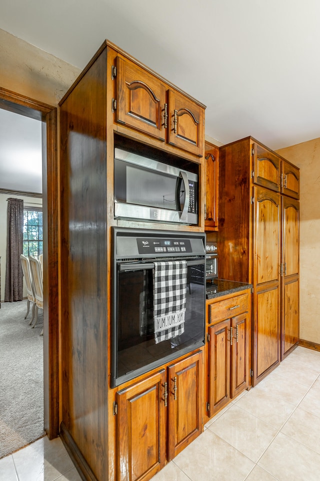 kitchen featuring black oven and light tile patterned floors