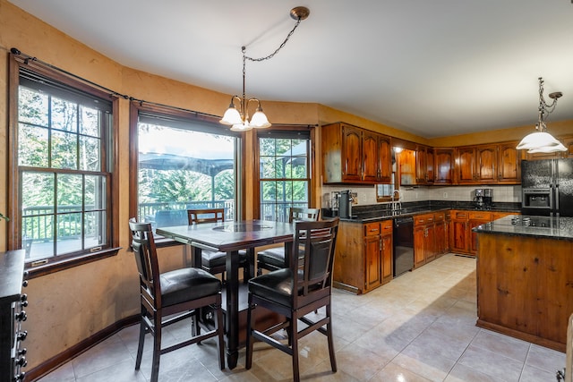 kitchen with tasteful backsplash, light tile patterned floors, a chandelier, black appliances, and decorative light fixtures