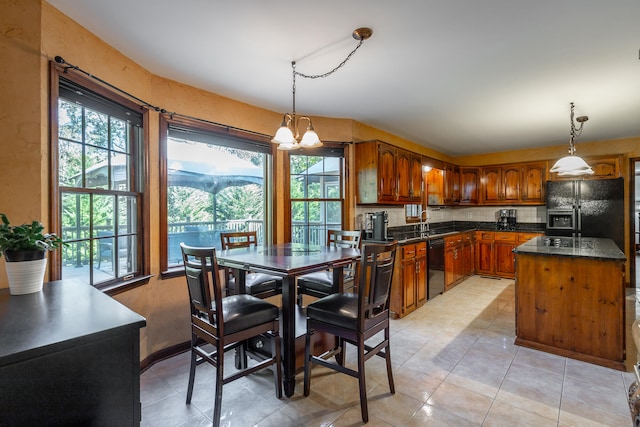 kitchen with black appliances, a wealth of natural light, and pendant lighting