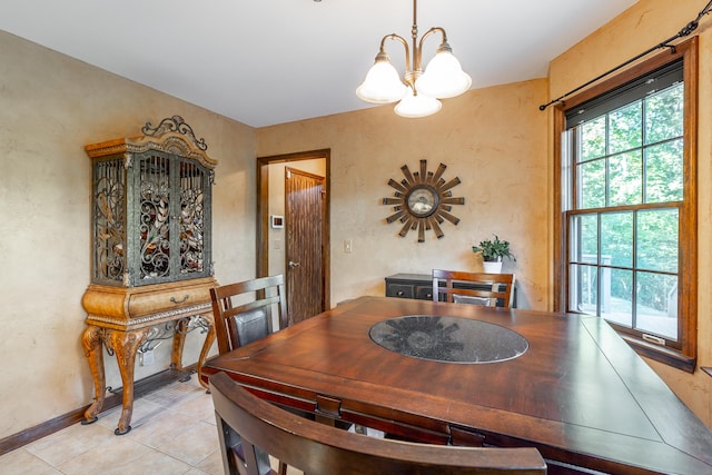 tiled dining room featuring a chandelier