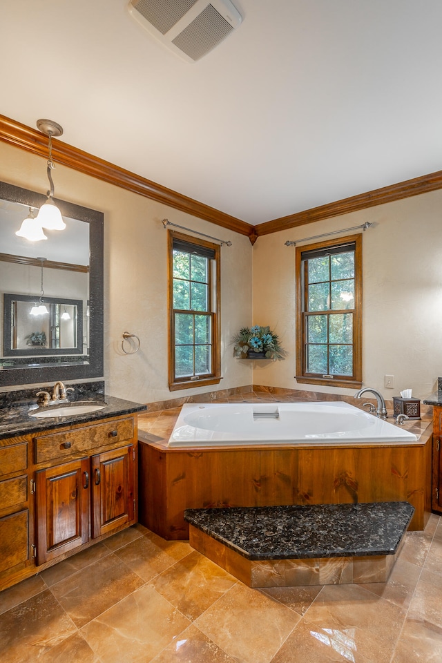 bathroom with vanity, ornamental molding, and a tub