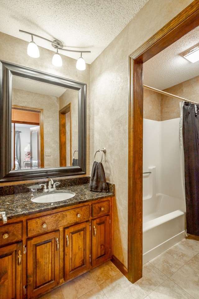 bathroom featuring tile patterned floors, rail lighting, vanity, a textured ceiling, and shower / bathtub combination with curtain