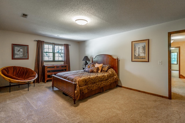 bedroom with light carpet and a textured ceiling