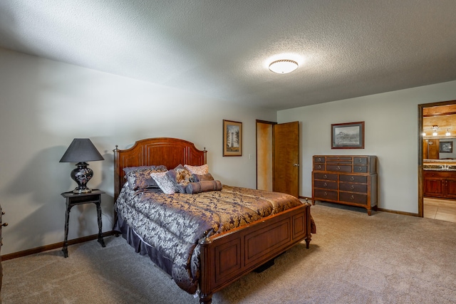 carpeted bedroom featuring ensuite bathroom and a textured ceiling