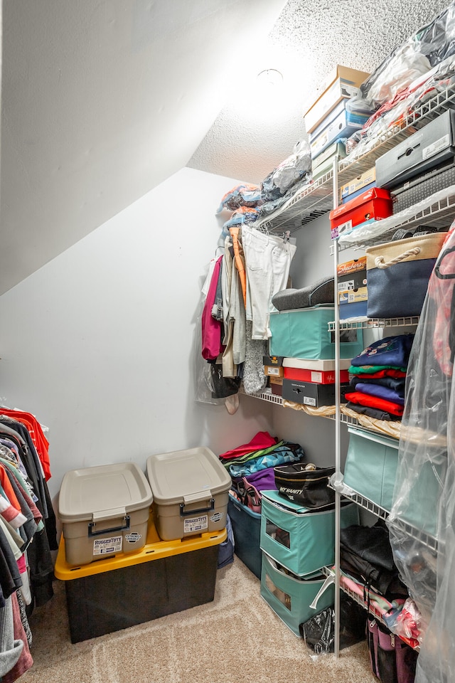 walk in closet featuring lofted ceiling and carpet