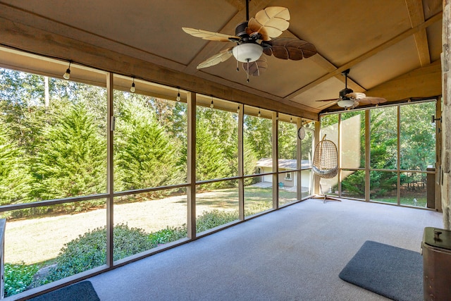 unfurnished sunroom featuring ceiling fan, a healthy amount of sunlight, and vaulted ceiling