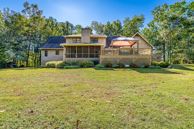 back of house featuring a gazebo, a wooden deck, a yard, and a sunroom