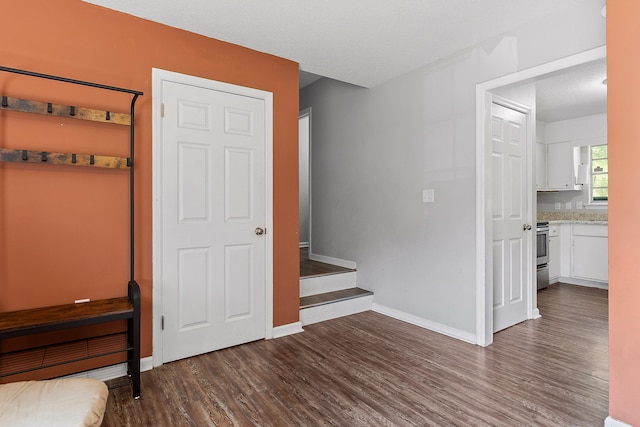 unfurnished bedroom with a textured ceiling, dark hardwood / wood-style floors, and ensuite bath