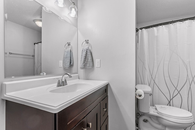 bathroom with toilet, a textured ceiling, and vanity