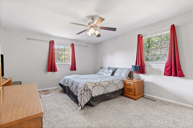 bedroom featuring ceiling fan, light carpet, and a textured ceiling