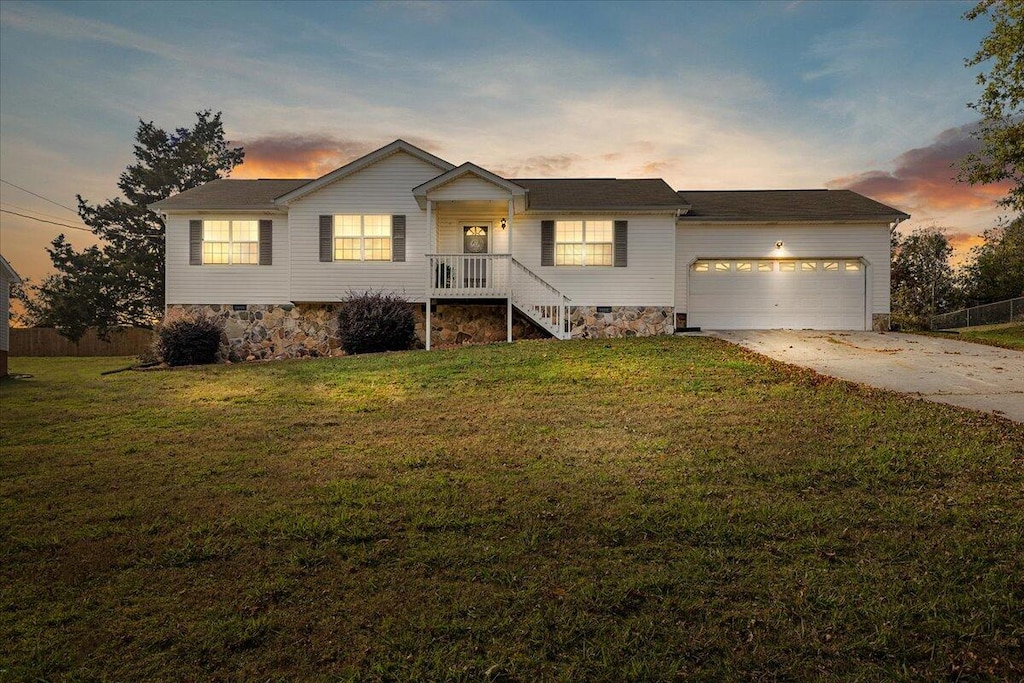 ranch-style house with a yard and a garage