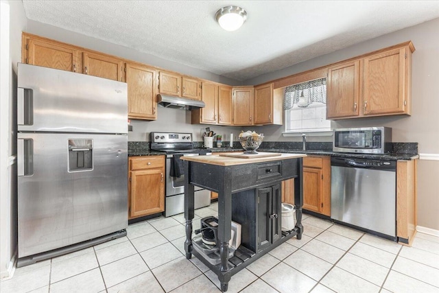 kitchen featuring sink, appliances with stainless steel finishes, a textured ceiling, and light tile patterned flooring