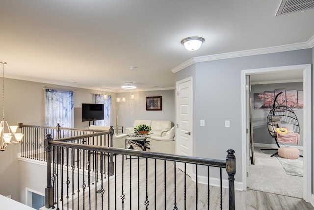 hall with light wood-type flooring and ornamental molding