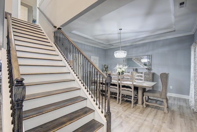 dining space featuring crown molding, light wood-type flooring, and an inviting chandelier