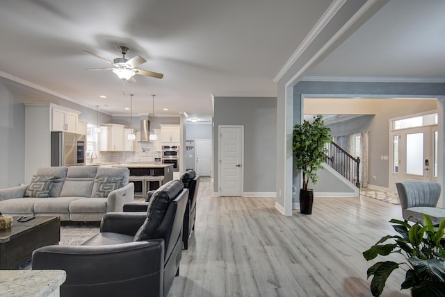 living room featuring ceiling fan, light hardwood / wood-style flooring, sink, and ornamental molding