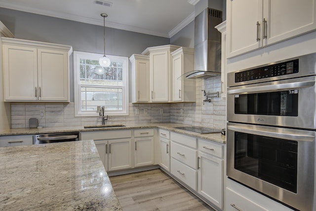 kitchen with white cabinets, wall chimney range hood, sink, and stainless steel appliances