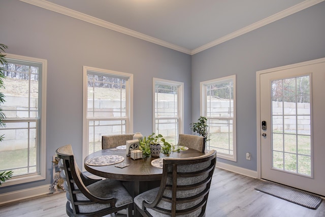 dining room with crown molding, plenty of natural light, and light wood-type flooring