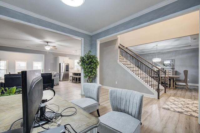 living room featuring ceiling fan with notable chandelier, light hardwood / wood-style floors, and crown molding