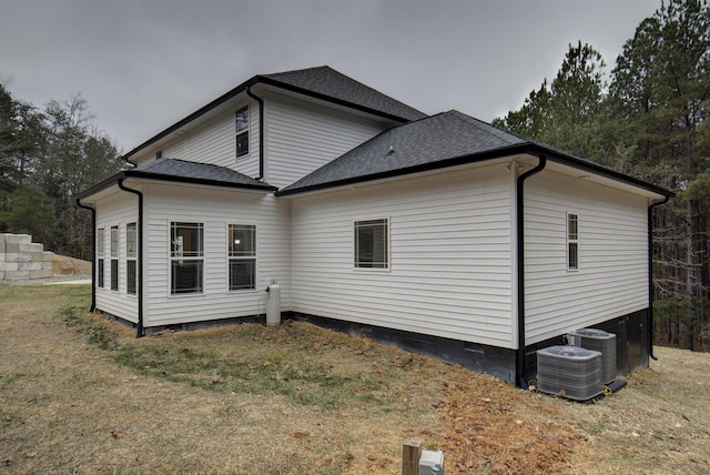 view of property exterior with a yard and central AC unit