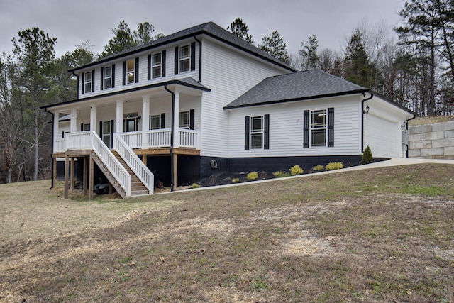 view of front of property with a front lawn, covered porch, and a garage