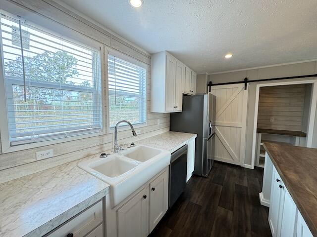 kitchen featuring white cabinetry, dishwasher, dark wood-type flooring, and a sink