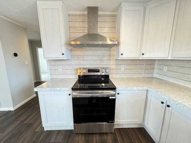 kitchen featuring electric range, white cabinetry, and wall chimney exhaust hood