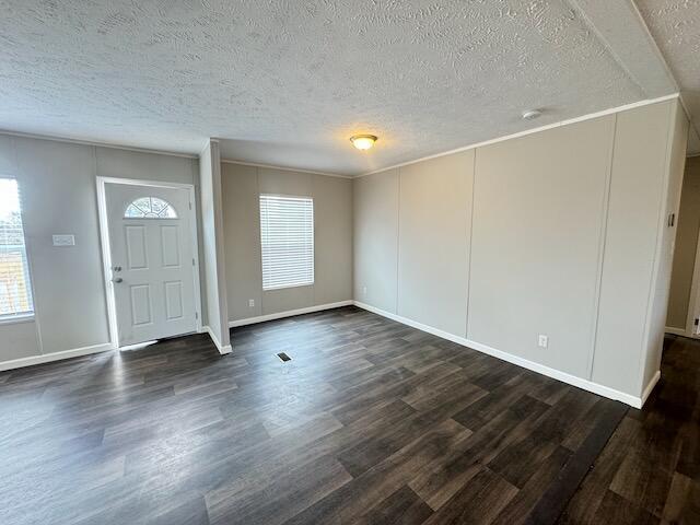 entryway with a textured ceiling, dark wood-style flooring, and baseboards