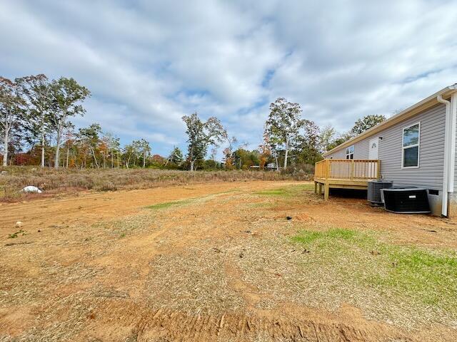 view of yard featuring a deck and central AC unit